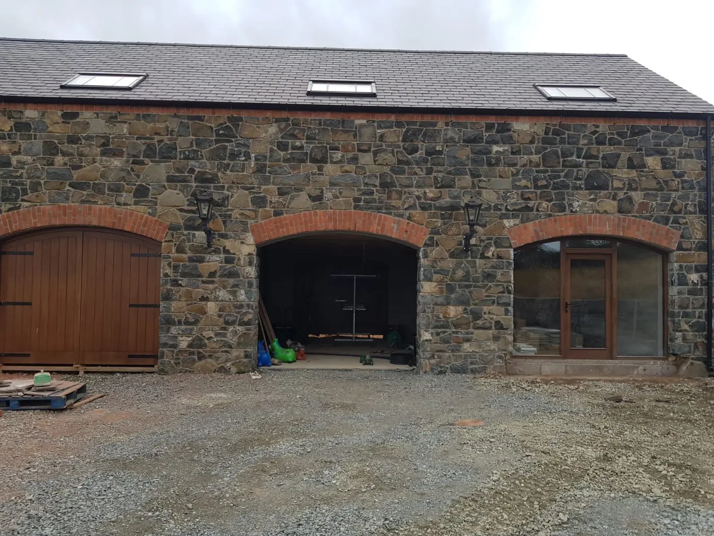 Completed Irish stone facade with brick arches over the garage openings